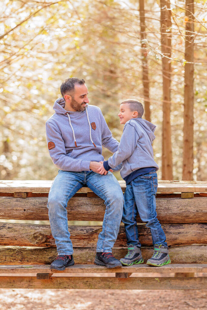 A father and son laughing and playing with each other during a photo session