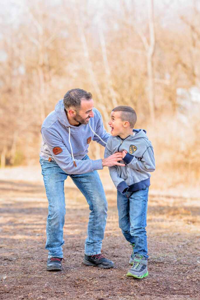 A father and son running and playing together during a photo session