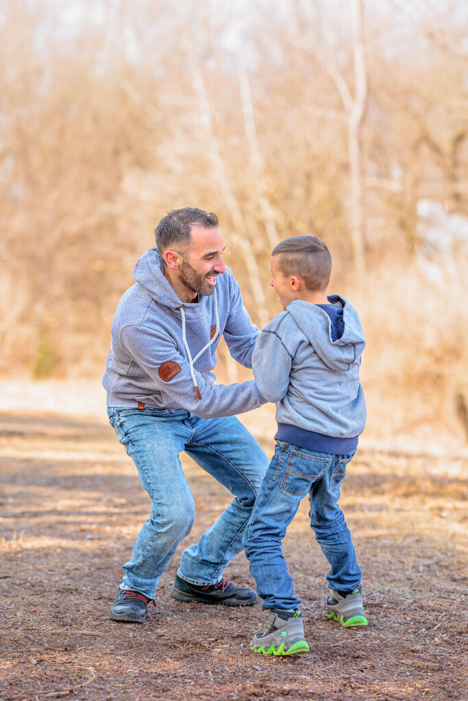 A father and son running and playing together during a photo session