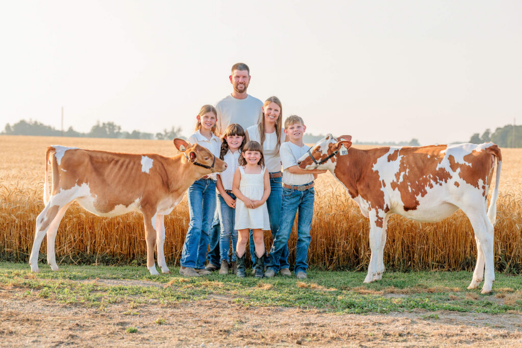 Family standing proudly with two 4H cows on their Thamesford dairy farm.